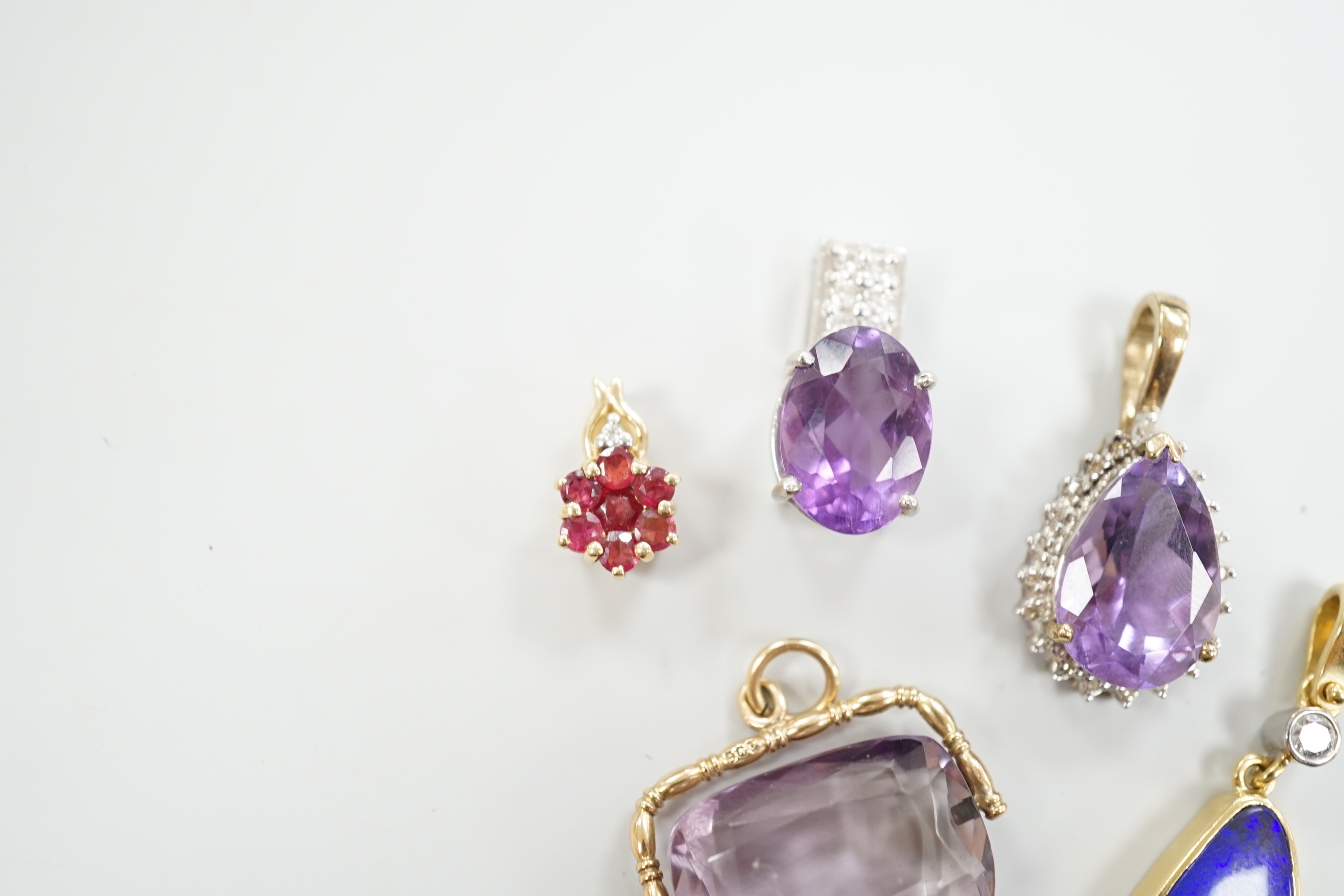 A white metal, stamped PT900, amethyst and diamond cluster set pendant, 18mm, gross weight 5.5 grams and four other pendants including three 9ct and gem set and a yellow metal and simulated opal and diamond, gross 13 gra